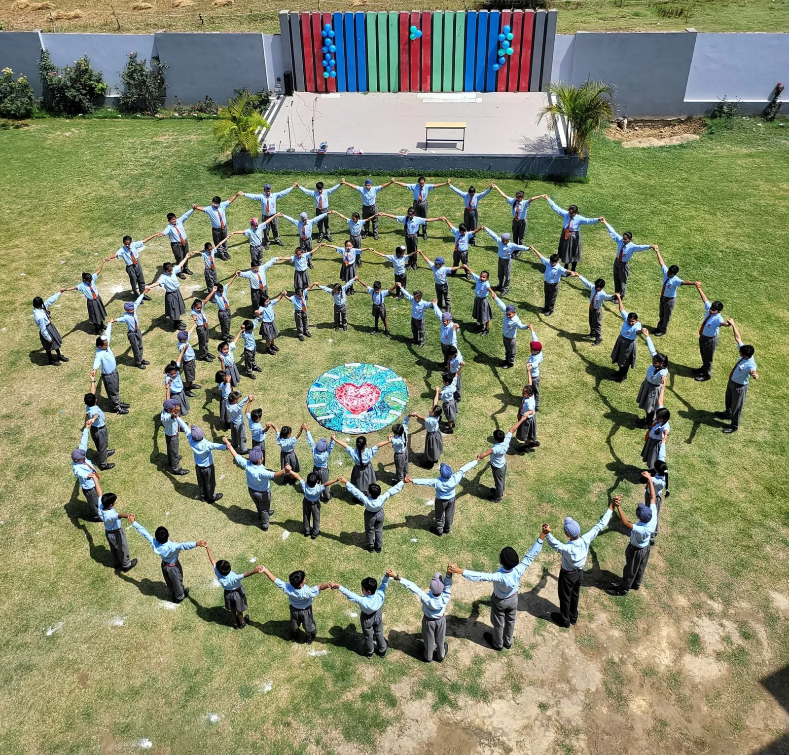 Students of Initium Global School forming circles on the campus grounds